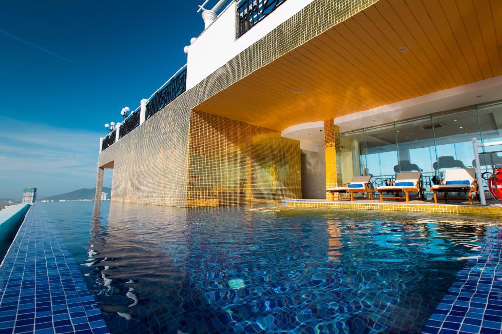 An infinity-style rooftop pool beside a covered sun deck with a coastal outlook.