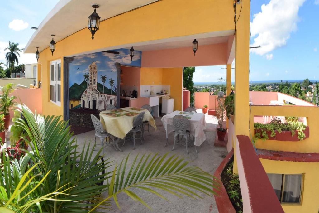 a yellow house with a table and chairs on a patio at Hostal Alcuria in Trinidad