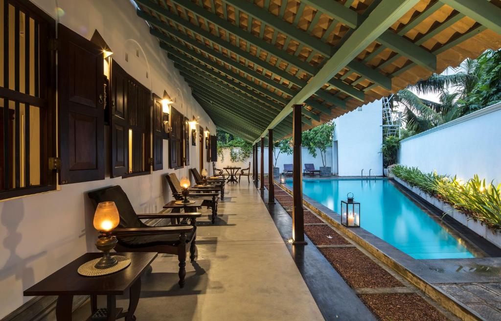 a resort with a pool and a row of chairs at Green Casa in Galle