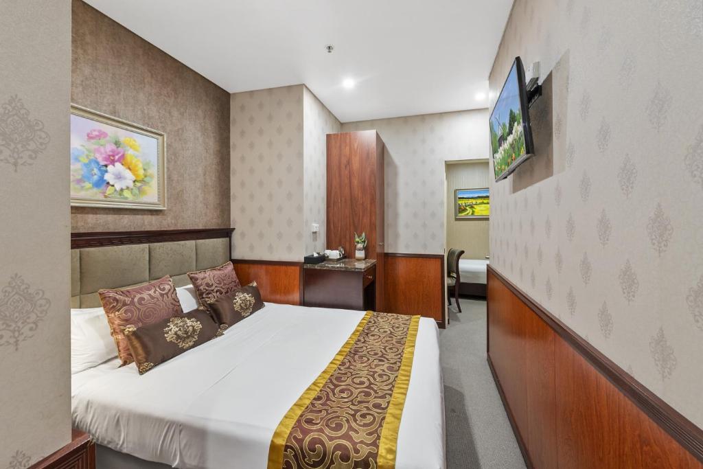 a hotel room with a bed and a tv at YEHS Hotel Sydney CBD in Sydney