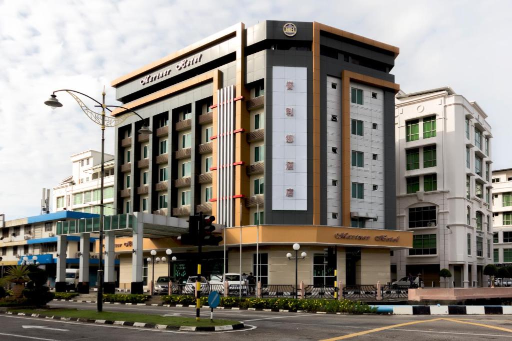 a building on a city street with a traffic light at Mariner Hotel Labuan in Labuan