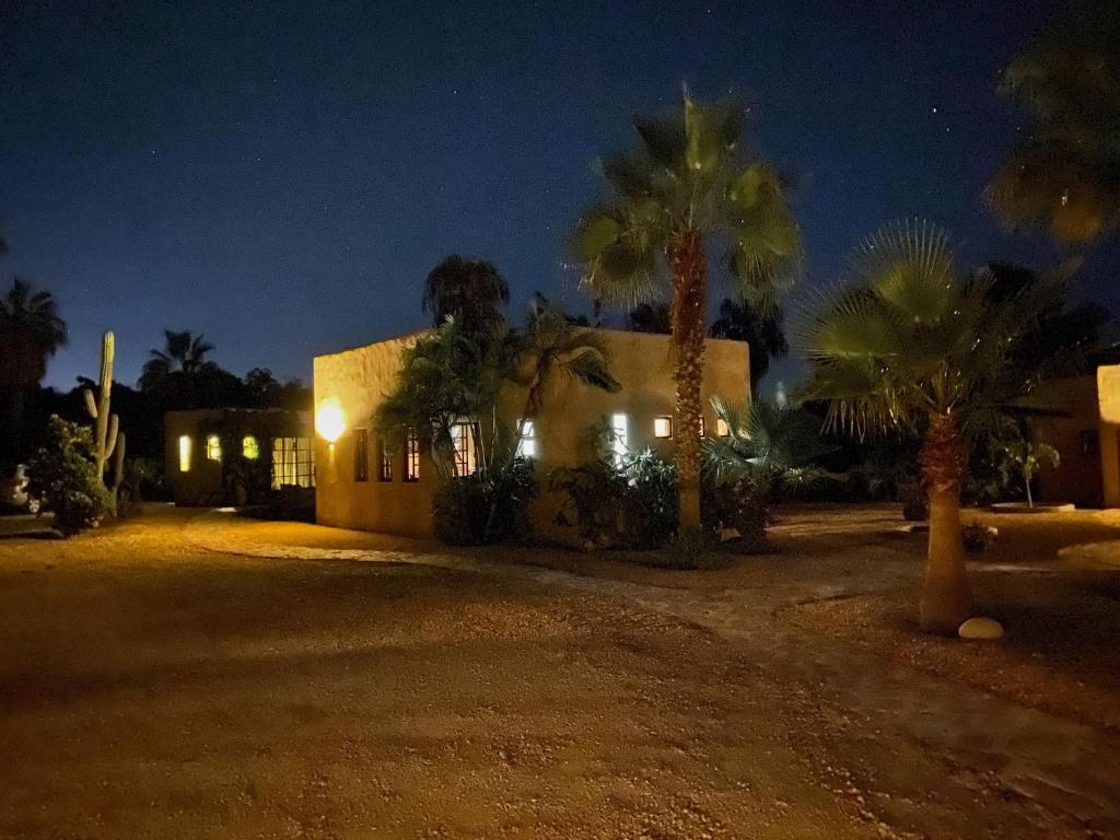 a house at night with palm trees in front of it at Sole Caliente in Todos Santos