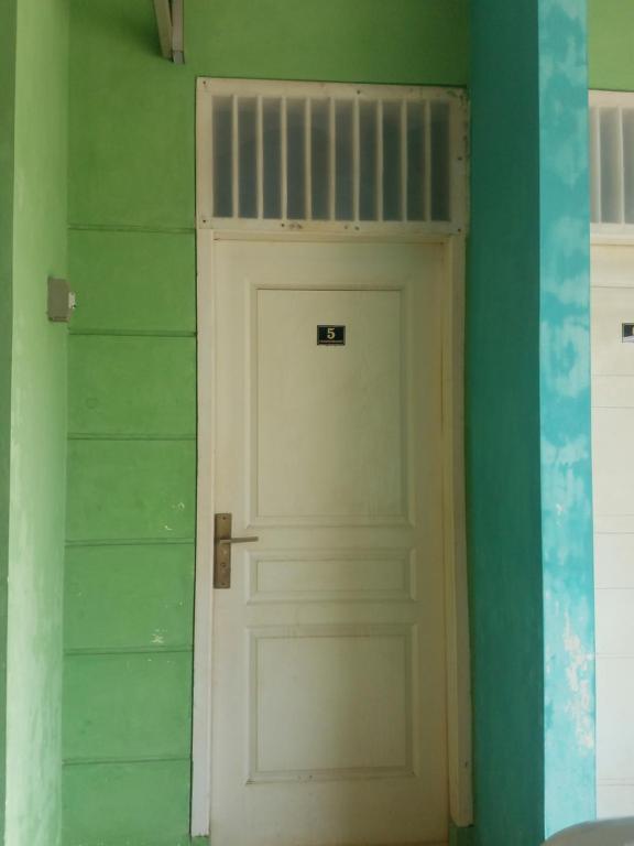 a white door in a room with a green wall at Cendrawasih Syariah Homestay in Lampung