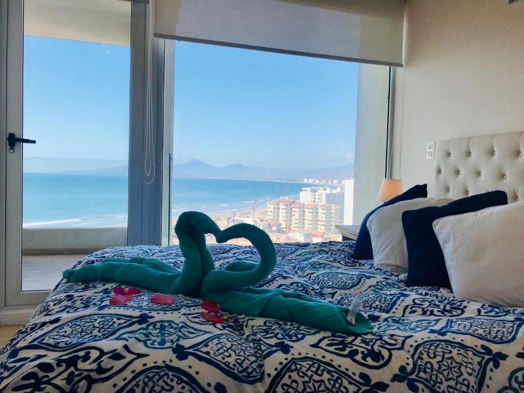 uma cama com dois cisnes em frente a uma janela em Honeymoon Apartment Club Océano em Coquimbo