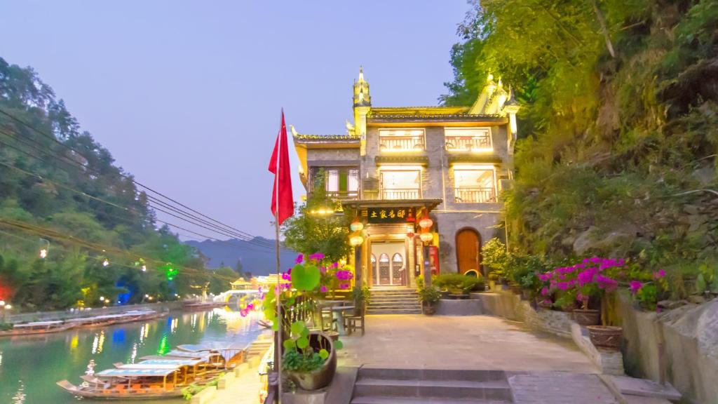 a building on the side of a river with a building at Fenghuang Tujia Ethnic Minority River View Hotel in Fenghuang County