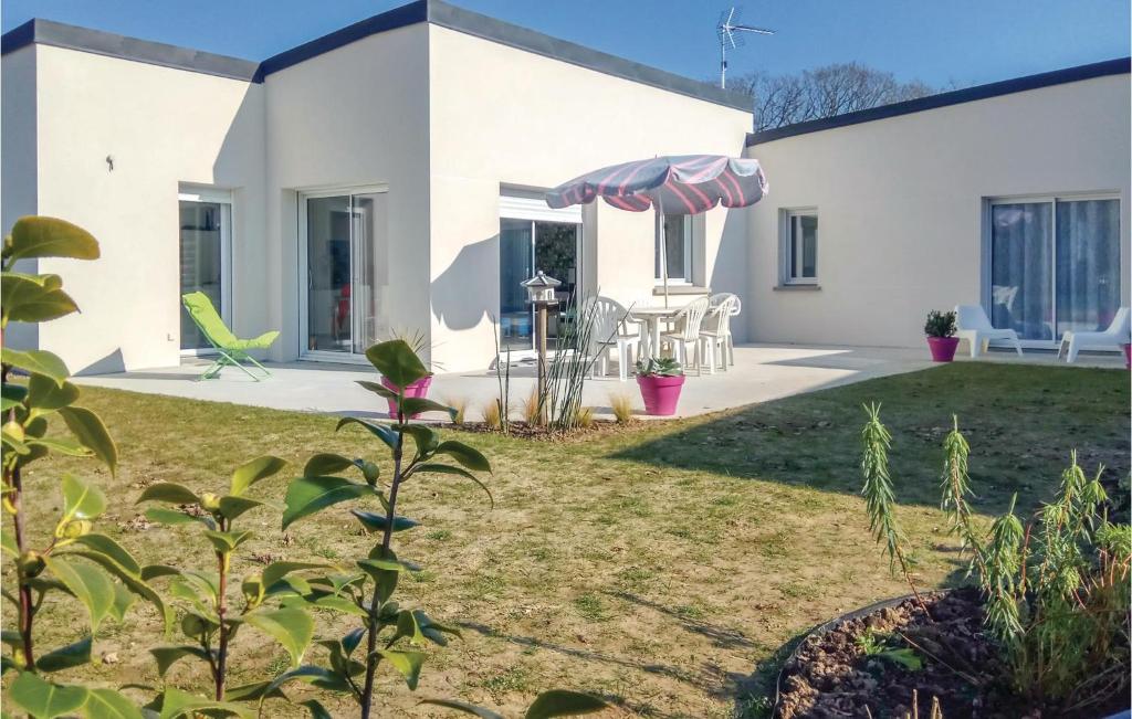 una casa con un patio con sombrilla en 3 Bedroom Beautiful Home In Matignon, en Matignon