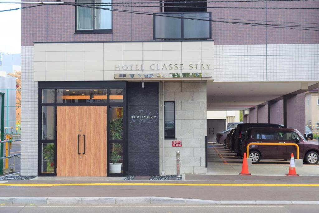 a hotel glassstay building with a wooden door on a street at Hotel Classe Stay Sapporo in Sapporo