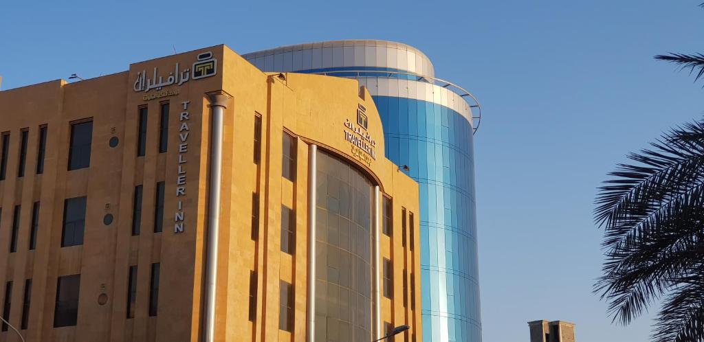 a hotel building with a glass dome and a palm tree at Travellerinn Serviced Apartment in Al Khobar