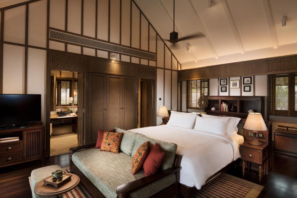 a bedroom with a large bed and a couch at Anantara Desaru Coast Resort & Villas in Desaru