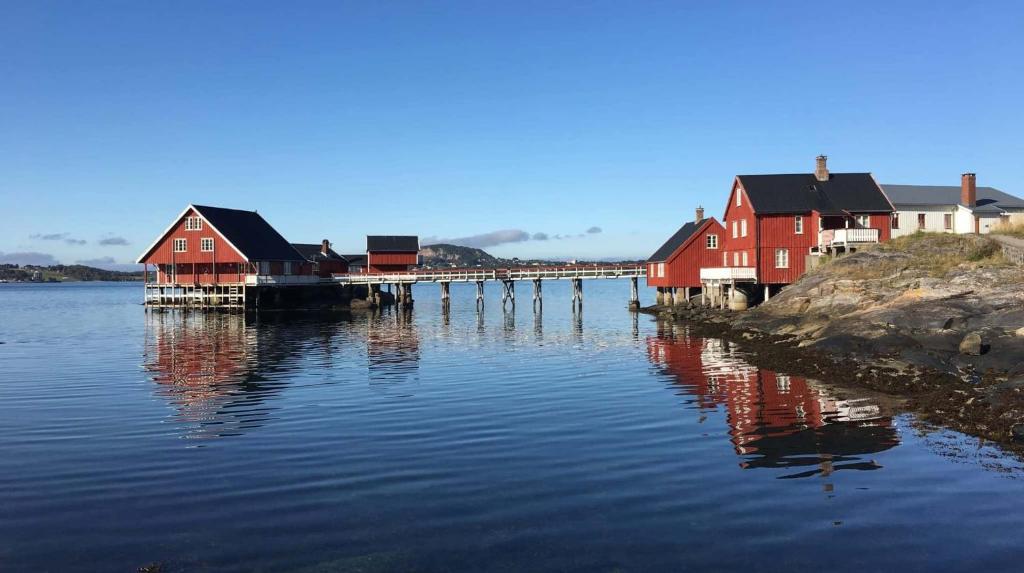 een groep rode huizen op het water bij Vikaneset Havhotell in Kristiansund