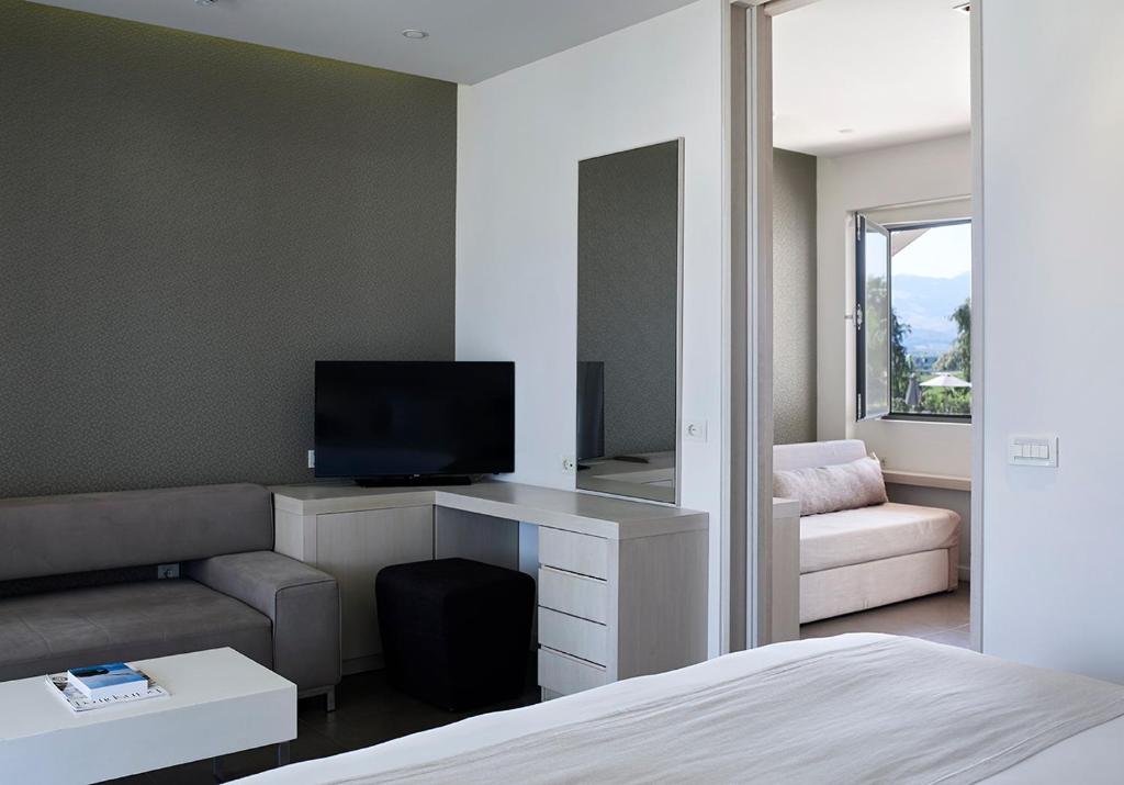 A television and/or entertainment centre at Pelagos Suites Hotel & Spa