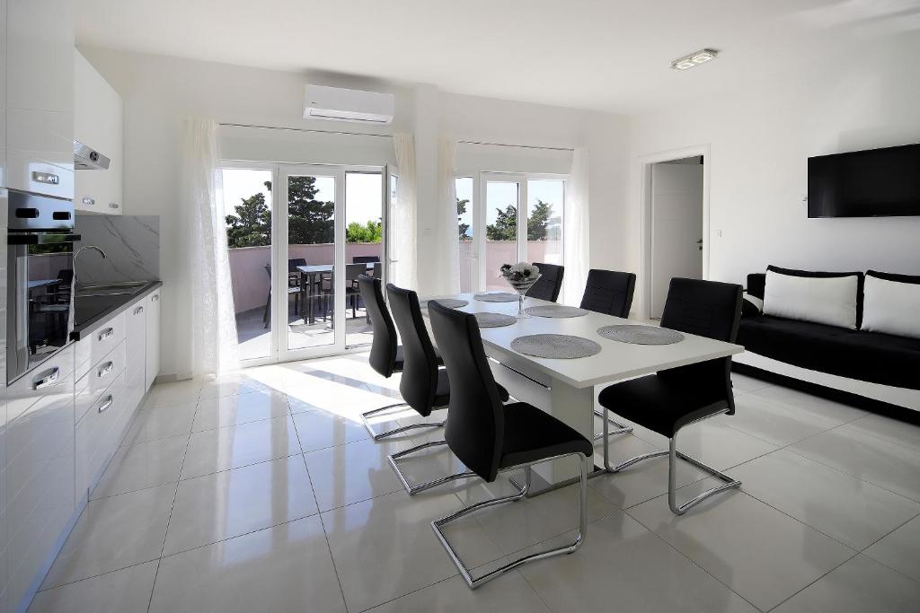 a kitchen and dining room with a table and chairs at Apartments Lola in Novalja