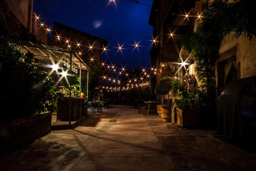 une allée éclairée avec des lumières sur un bâtiment la nuit dans l'établissement El Folló Turisme Rural, à Tagamanent