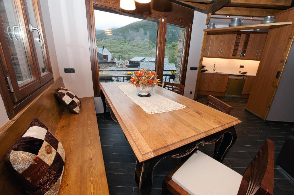 a dining room with a table and a large window at Casa Llop in Espot