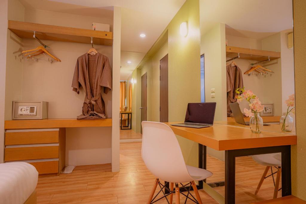 A bedroom workstation facing a mirror, beside an open wardrobe and safe.