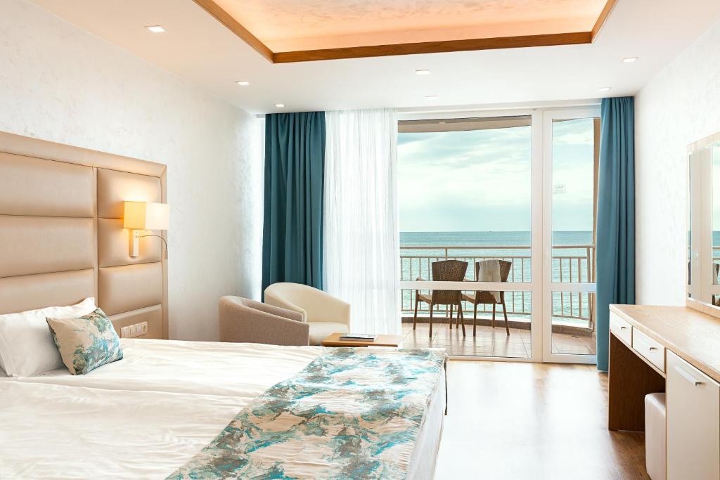 a hotel room with a bed and a view of the ocean at Bilyana Beach Hotel - All Inclusive & Free Beach Access in Nesebar