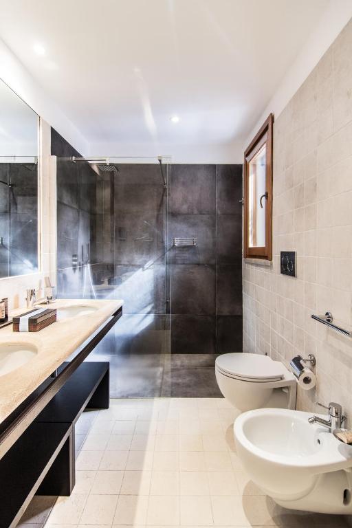 a bathroom with a sink and a toilet and a shower at Hotel Aquadulci in Chia