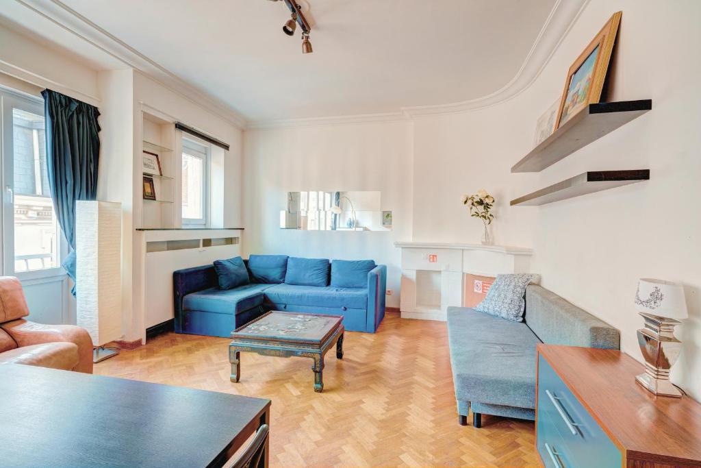 a living room with a blue couch and a table at Cozy Apartment on Best Location in Antwerp in Antwerp