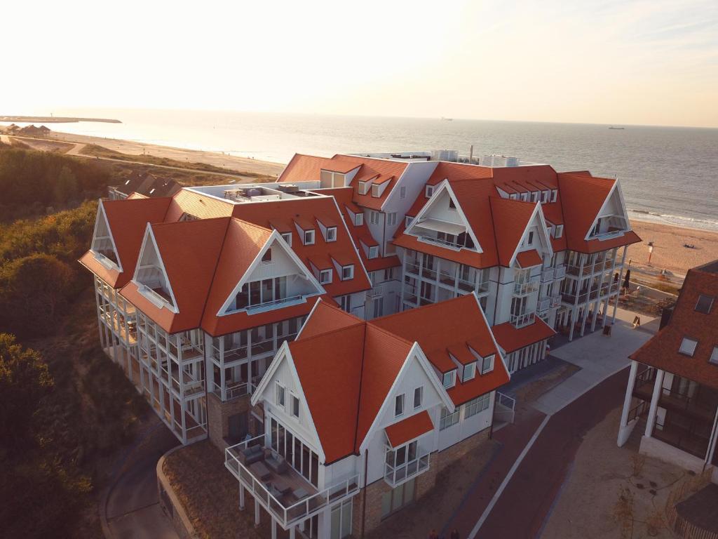 une vue aérienne sur un bâtiment avec des toits orange dans l'établissement Familie beachhuis op de duinen (Duinhuis), à Cadzand