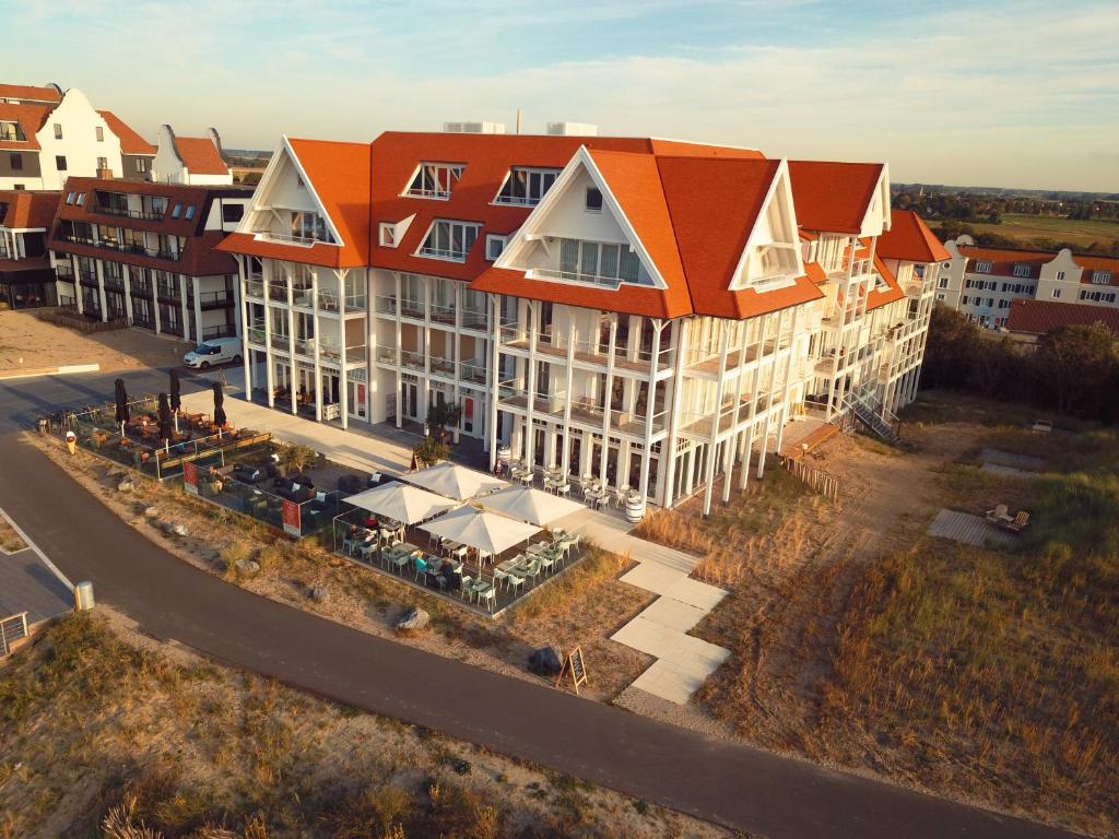 une vue aérienne sur un grand bâtiment avec un toit orange dans l'établissement Penthouse in Badhuis Cadzand, à Cadzand