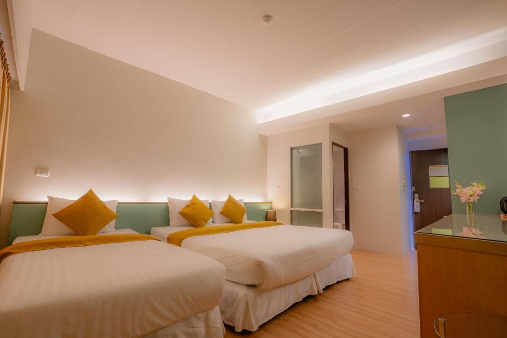 A twin room presents two separate beds in a spacious, simply furnished interior.