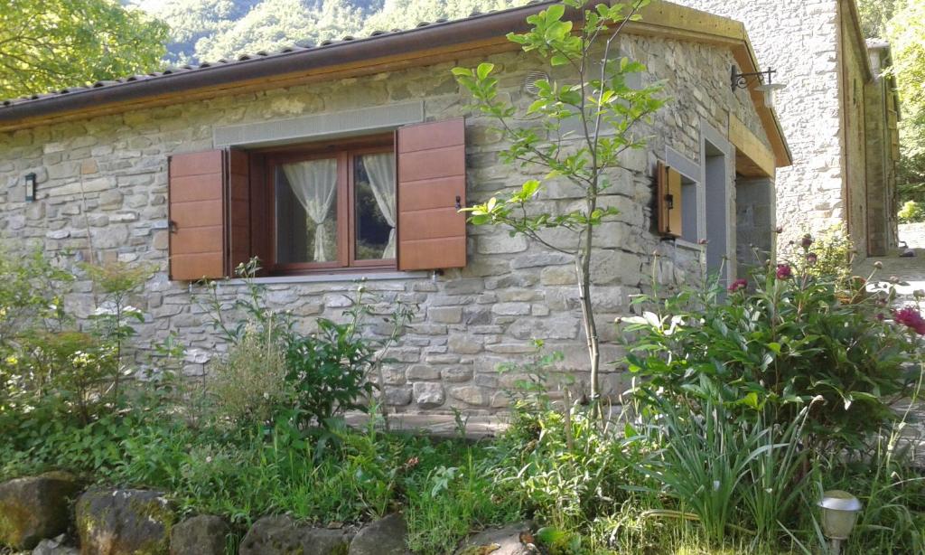 a stone house with a window and some plants at La casetta di Coradosso in Selvapiana