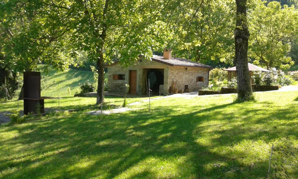 an old stone house in a field with trees at Agriturismo Coradosso "La casetta" in Selvapiana