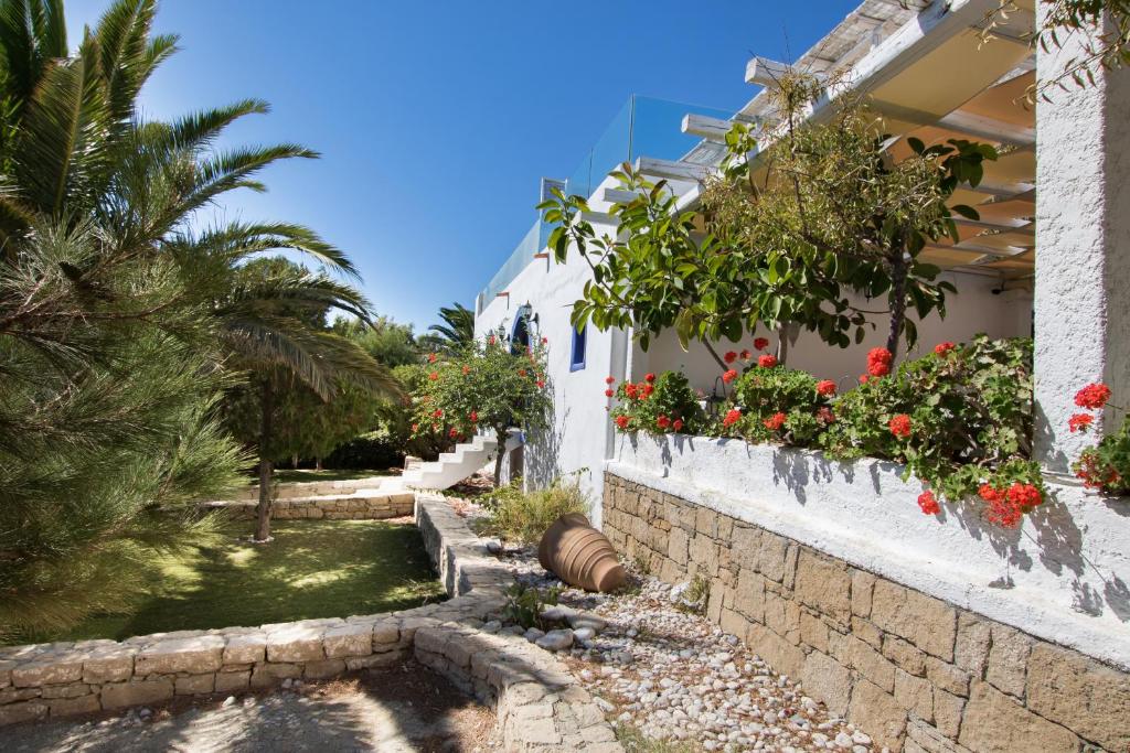 a house with flowers on the side of it at Poseidon Blue Gastronomy Hotel in Afiartis