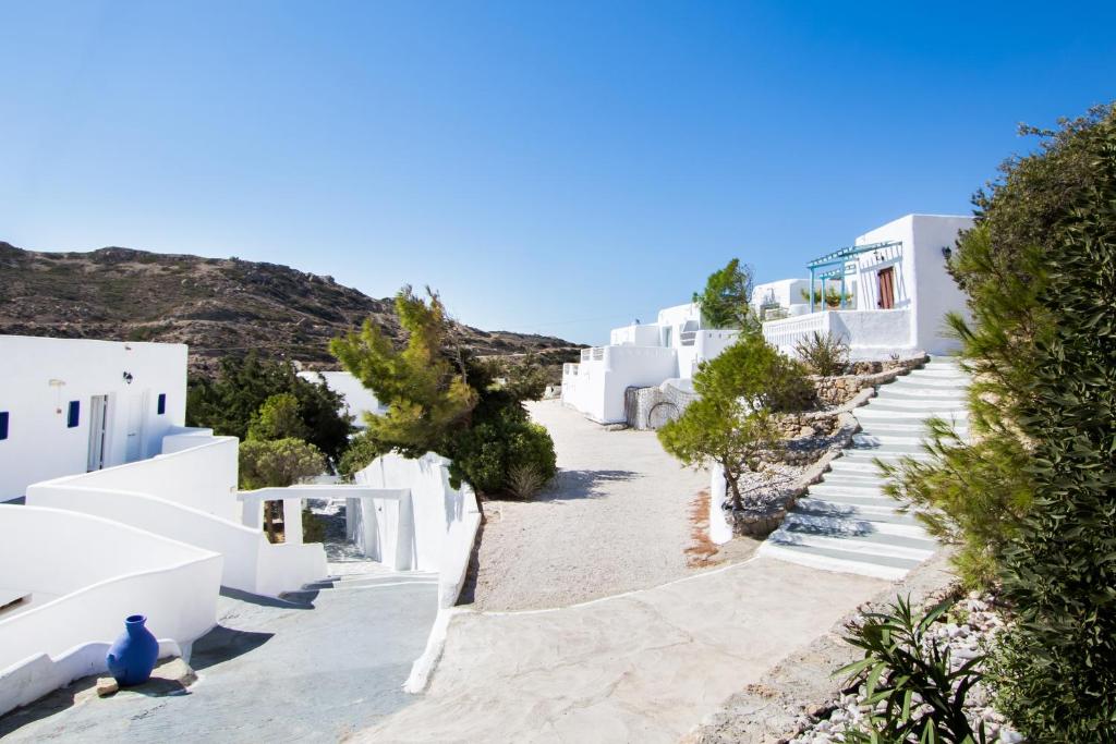 a street of white buildings with trees and bushes at Poseidon Blue Gastronomy Hotel in Afiartis