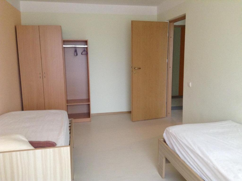 a room with two beds and two closets in it at Hostelis Zaļā muiža in Zaļenieki