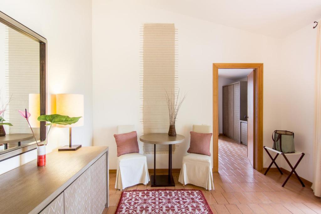 a living room with a table and chairs and a mirror at Hotel Aquadulci in Chia