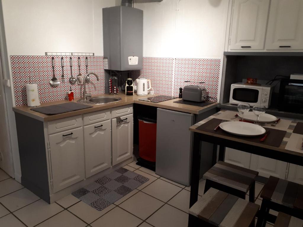 una pequeña cocina con fregadero y microondas en le petit dieppois, en Dieppe