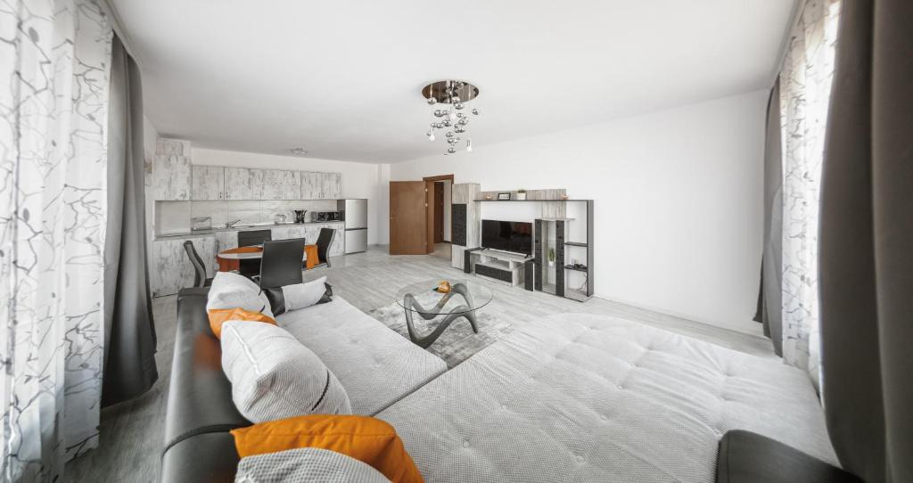 ein Wohnzimmer mit einem Sofa und einer Küche in der Unterkunft NEXT TO GONDOLA Stylish and Charming apartment in Bansko