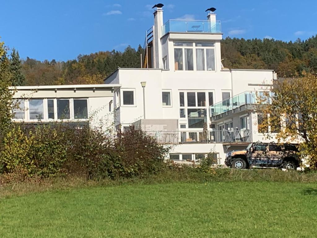 a truck parked in front of a large white house at Ferienwohnung Kaiserpanorama in Krumpendorf am Wörthersee
