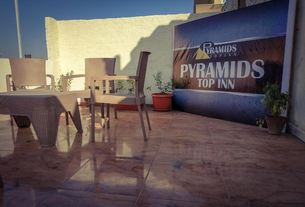 a patio with tables and chairs and a sign for a pepsi at Pyramids Top Inn in Cairo