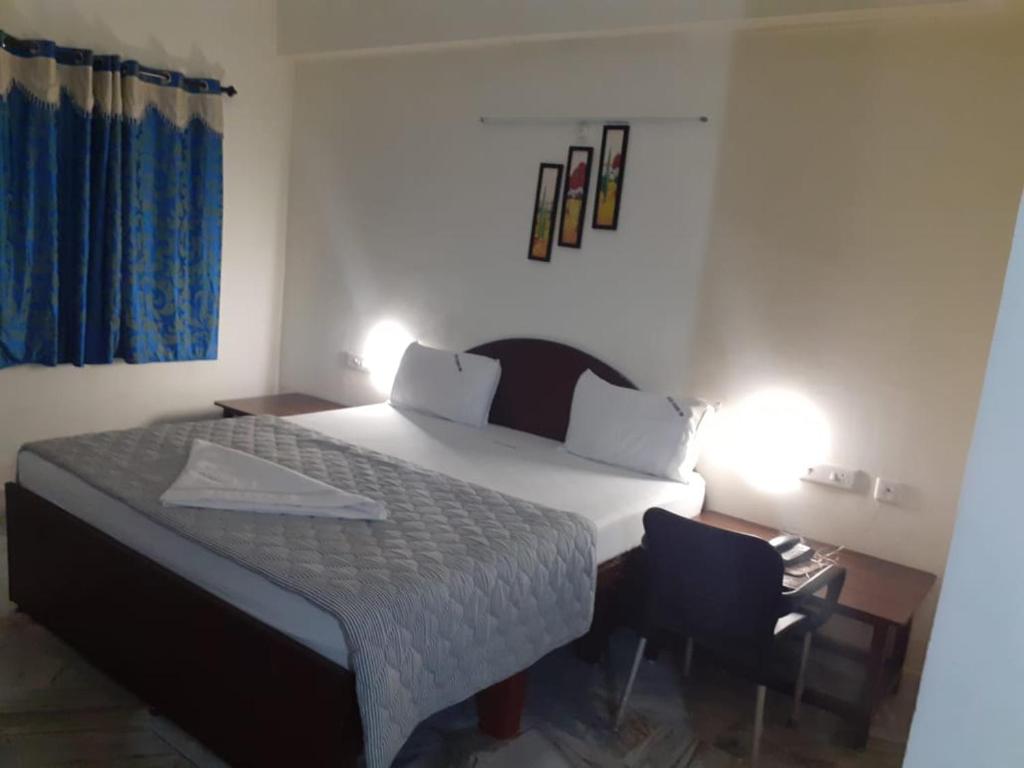 ein Schlafzimmer mit einem großen Bett und einem Stuhl in der Unterkunft Hotel Paradise Inn in Tiruppūr