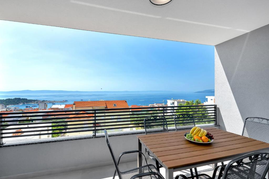 a wooden table with a bowl of fruit on a balcony at Luxury apartment Macola Free beach parking in Makarska