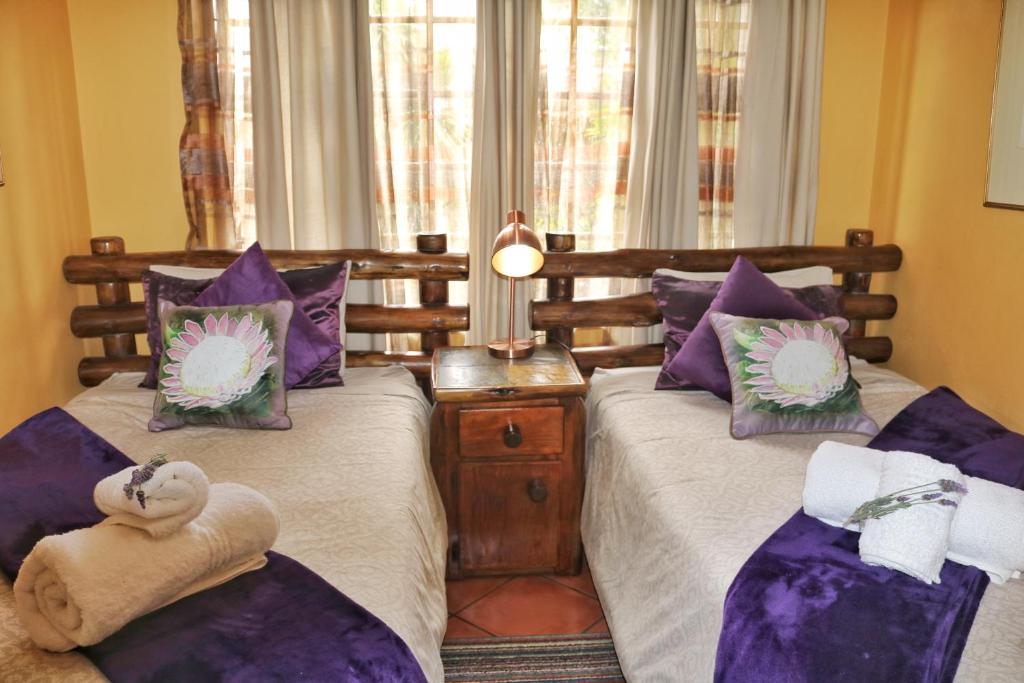 - 2 lits dans une chambre avec des oreillers violets dans l'établissement Kairos Home, à Middelburg