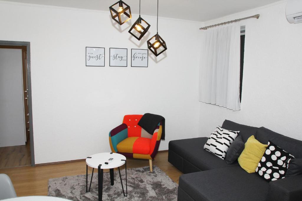 een woonkamer met een bank en een stoel bij Apartman Zen in Osijek