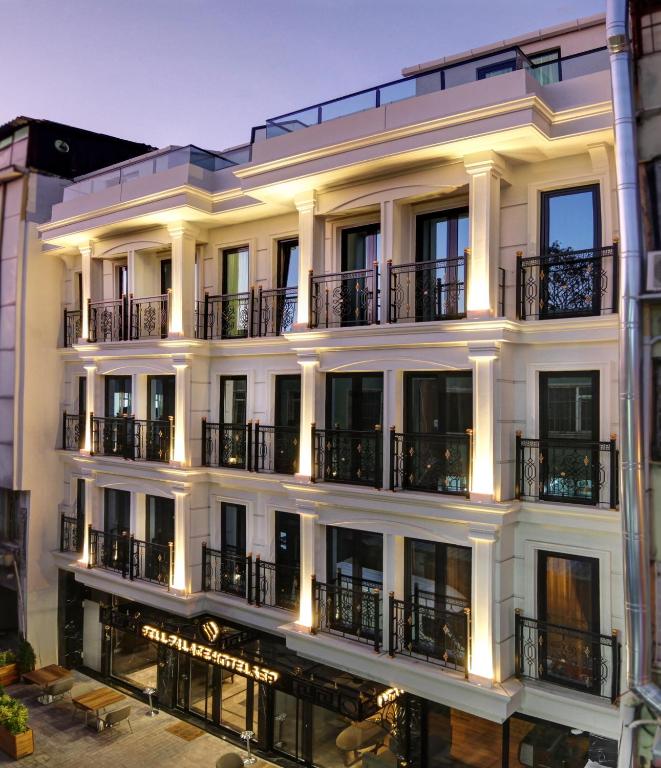a large white building with balconies and lights at Pell Palace Hotel & SPA in Istanbul