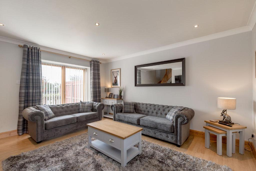 a living room with two couches and a mirror at The Steadings - by StayDunfermline in Dunfermline