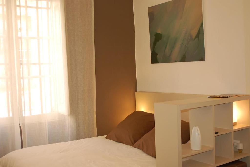 um quarto com uma cama com uma mesa branca e uma janela em Coeur de ville em Aix-en-Provence