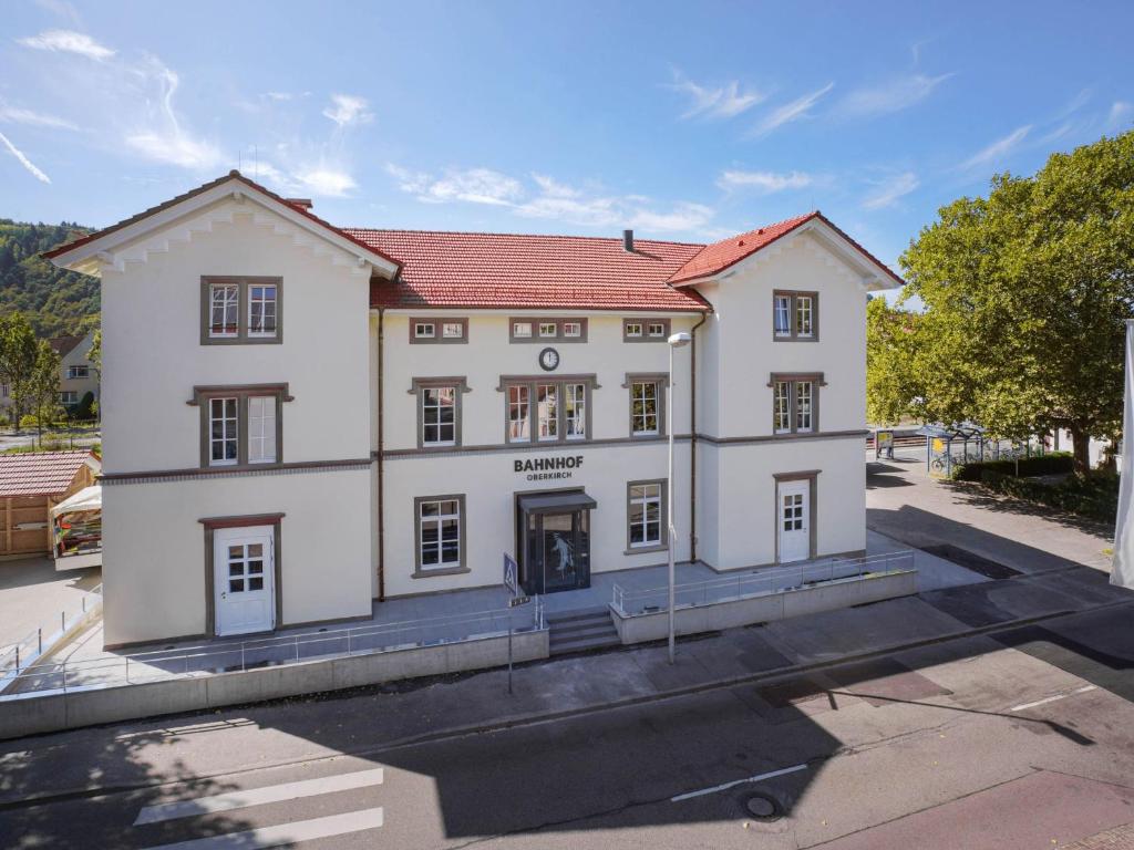 un gran edificio blanco con techo rojo en Bahnhof Oberkirch en Oberkirch