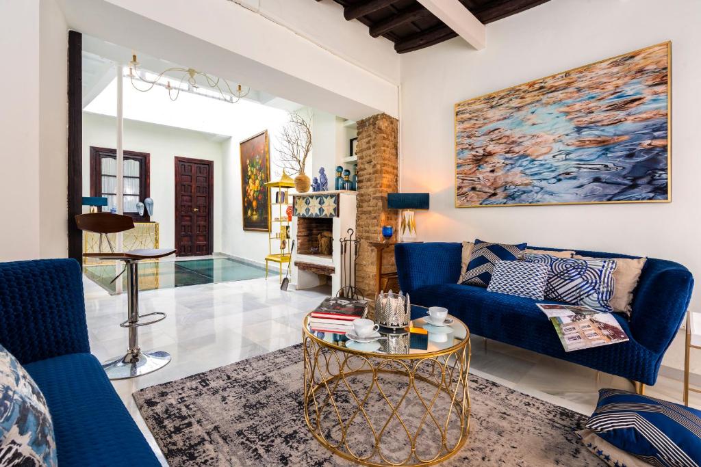 sala de estar con muebles azules y chimenea en HSH Select Casa Pilatos, en Sevilla