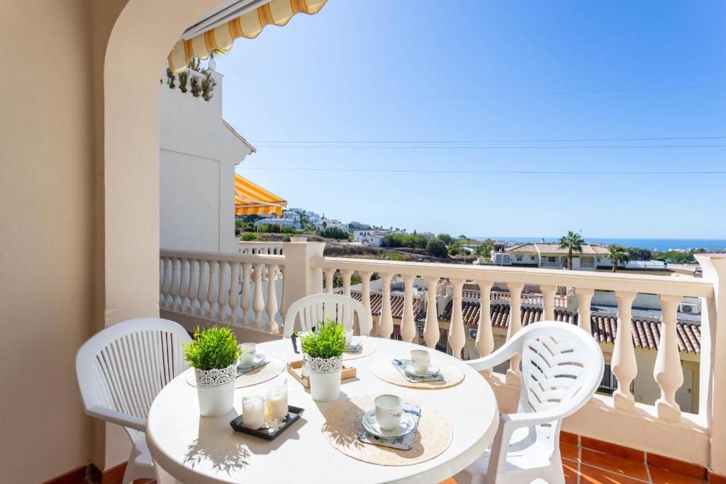 a white table with white chairs on a balcony at Apartamento Montesol 80 in Torrox Costa