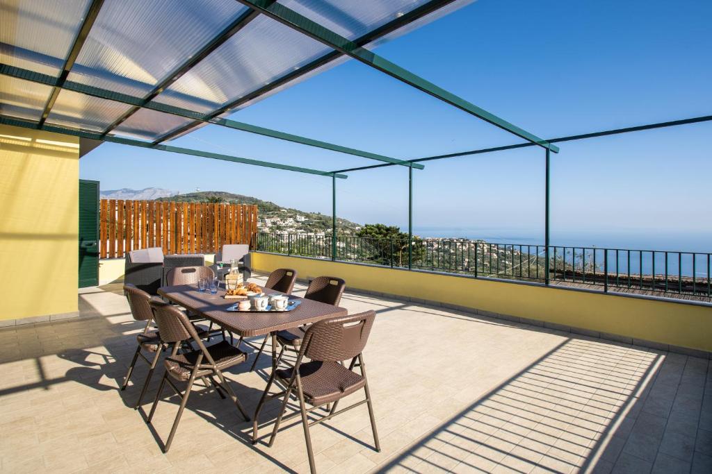 a patio with a table and chairs on a balcony at Magdalene's House - sea view terrace in Massa Lubrense