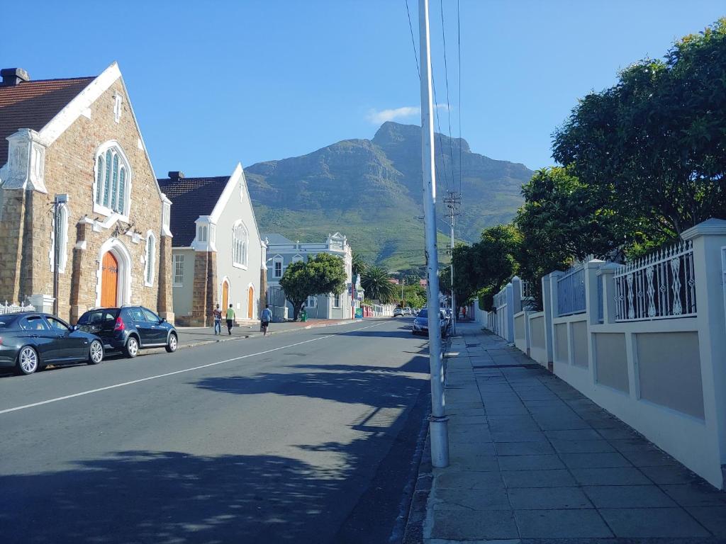 uma rua da cidade com uma montanha ao fundo em Happy Home - Woodstock em Cidade do Cabo