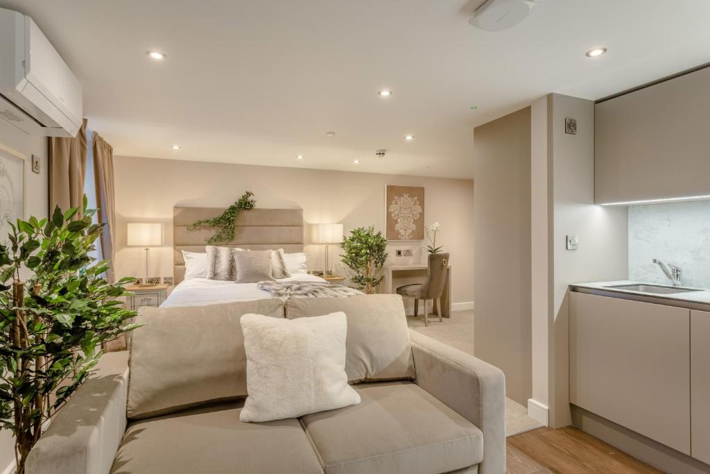 a bedroom with a bed and a couch and a kitchen at Heritage Mews Nottingham in Nottingham