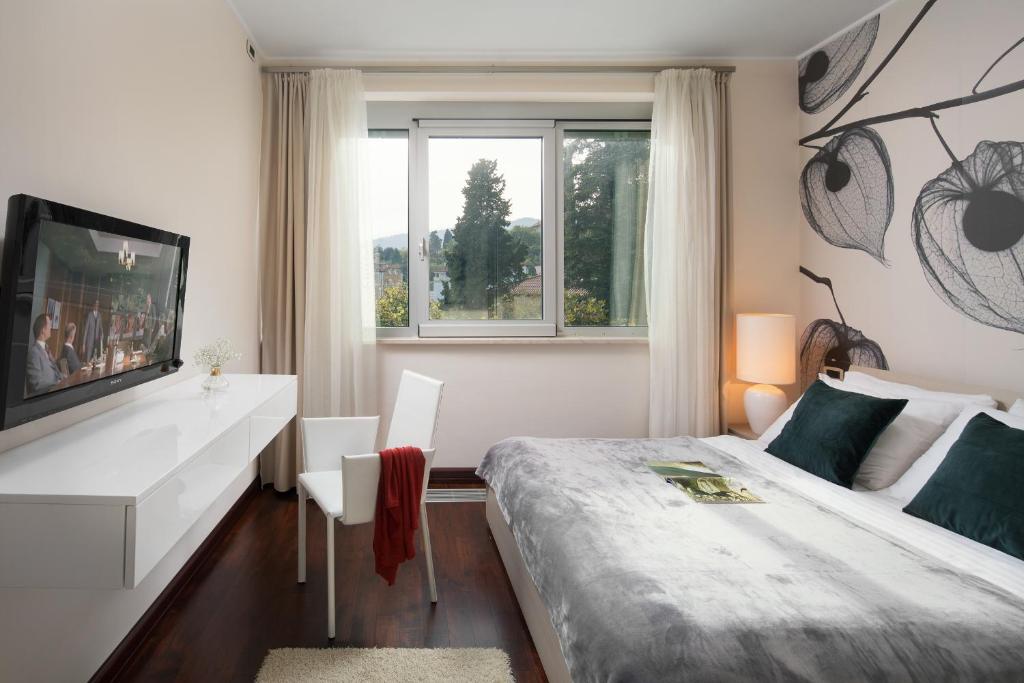 sypialnia z łóżkiem, telewizorem i oknem w obiekcie Villa Arentz Residence - Front Sea Apartments w mieście Opatija