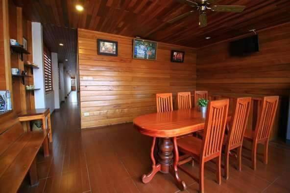 a wooden dining room with a wooden table and chairs at บ้านพักศรีสมบูรณ์ เชียงคาน in Chiang Khan